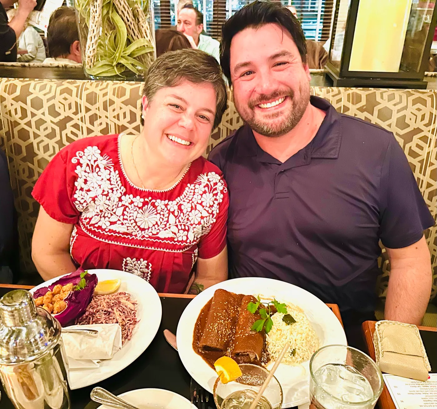 A couple celebrating over mole enchiladas in a banquette at Manuel's