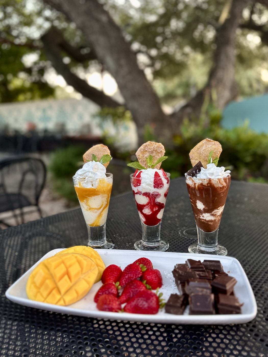 A trio of dessert parfaits and a sampler of mango, strawberries and chocolate on Manuel's patio