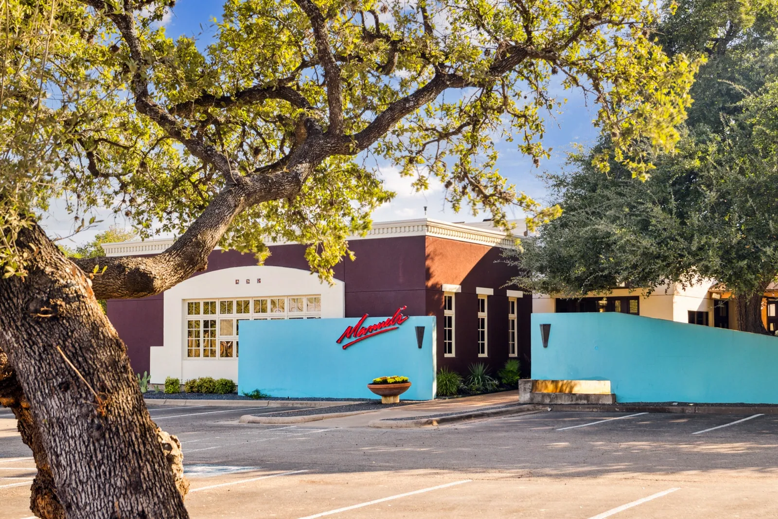 Manuel's turquoise exterior framed by the live oak, at the Arboretum in Northwest Austin